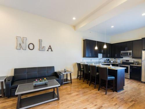 a living room with a couch and a kitchen at Beautiful Condos Steps from French Quarter and Bourbon St in New Orleans