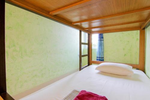 a bed in a room with a large window at Yani Homestay in Padang