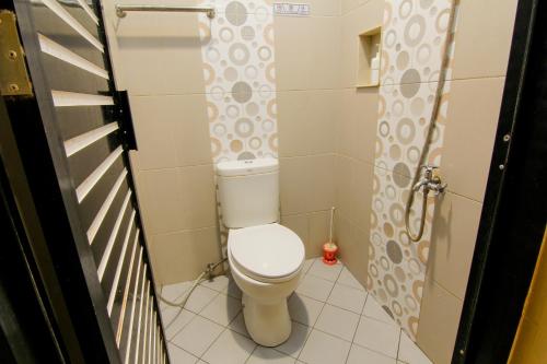 a small bathroom with a toilet in a stall at Yani Homestay in Padang