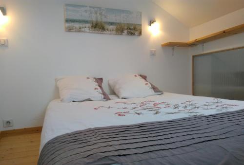 a bedroom with a large bed with two pillows at 1 appartement 2 chambres plus salon ,3 appartements rénovés , NETFLIX, lits faits à votre arrivée, serviettes de toilette, Ménage, Wifi, en hyper centre ,Plage à 190m, BOX à Vélos, paiement 3 fois sans frais, prix tout compris in Dieppe
