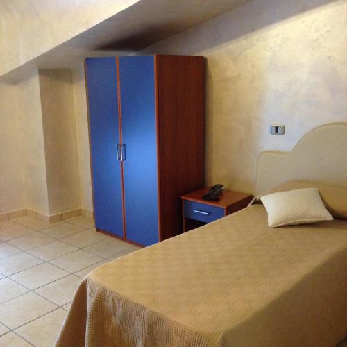 a bedroom with a bed and a blue cabinet at Tea Palace Hotel in Casapulla