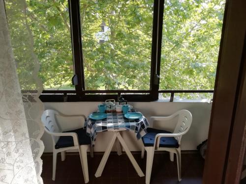 tavolo e sedie in una stanza con finestra di Azúr apartman a Harkány