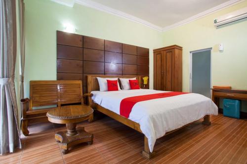 a bedroom with a large bed with red pillows at RedDoorz near Juanda International Airport in Surabaya