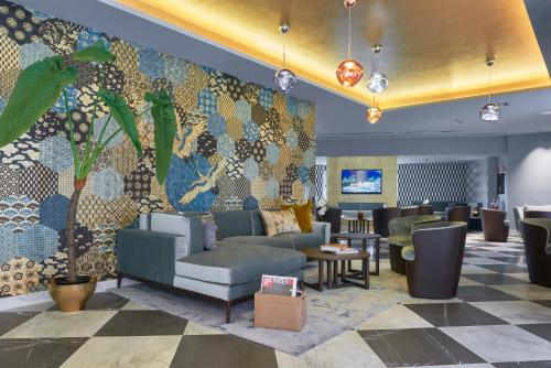 a lobby with couches and a wall with a mural at Hotel Michelangelo in Carrara