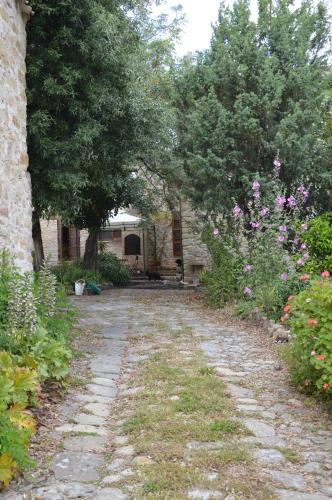 a stone path in a garden with trees and flowers at Sa Domu de sa Contissa in Sèlegas