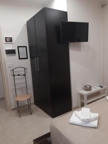 a black cabinet in a room with a chair at La dimora di Vituccio B&B in Avetrana