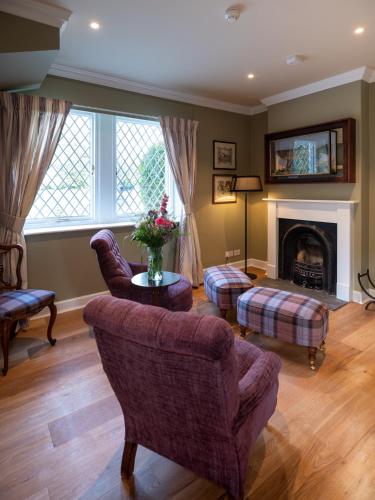 a living room with two chairs and a fireplace at SCHLOSS Roxburghe, part of Destination by Hyatt in Kelso