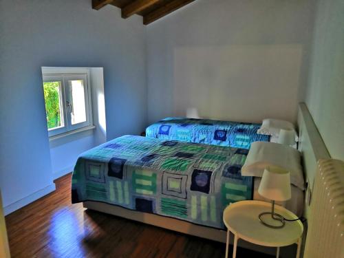 a bedroom with a bed and two chairs and a window at BellaGiò Apartment pool free parking near lake in Bellagio