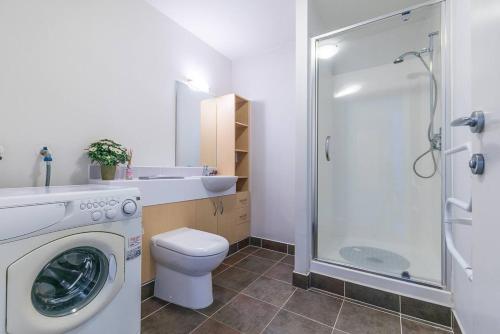 a bathroom with a washing machine and a shower at Wonderful Apartment in Quiet CBD Neighbourhood! in Auckland
