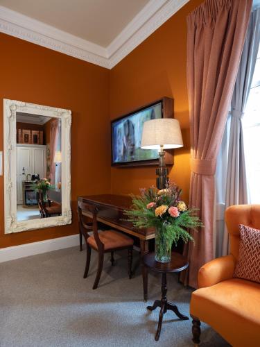 a living room with a desk and a mirror at SCHLOSS Roxburghe, part of Destination by Hyatt in Kelso