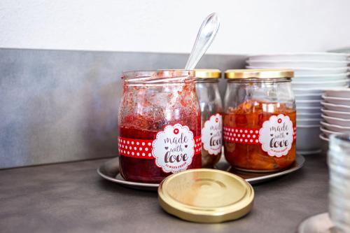 two jars of jam on plates with labels on them at Villa Sachsenhof - Pension - Frühstück buchbar - nur 700m vom Gesundheitsbad ACTINON in Bad Schlema