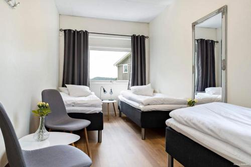 a hotel room with three beds and a mirror at Alkoven Logi in Ullared
