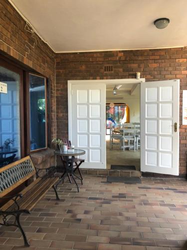 a patio with a bench and a door and a table at Seaside Lodge B&B in Ballito