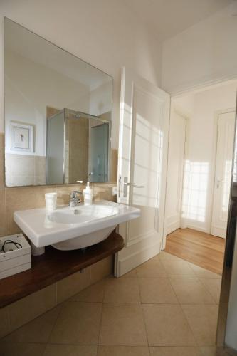a bathroom with a sink and a large mirror at Pisacane61 B&B in Modena