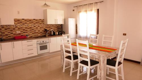een keuken met een houten tafel en stoelen in een kamer bij Large apartment on golf course in San Miguel de Abona