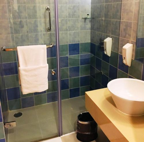 een badkamer met een douche, een wastafel en een toilet bij Hometel Chandigarh in Chandīgarh