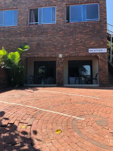 a brick building with a brick driveway in front of it at Seaside Lodge B&B in Ballito