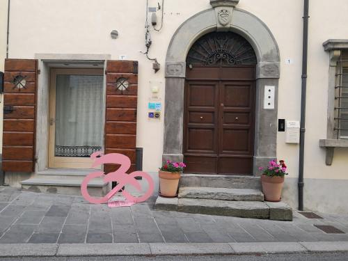 a house with a door and a pink sign in front at Il Vecchio Comune in Santa Sofia