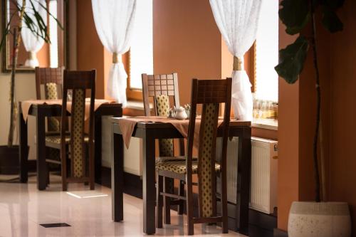 a dining room table and chairs in a room with a window at Vinci Hotel Airport in Modlniczka