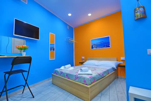 a blue and orange bedroom with a bed and a chair at Da Zia Geppina in Naples