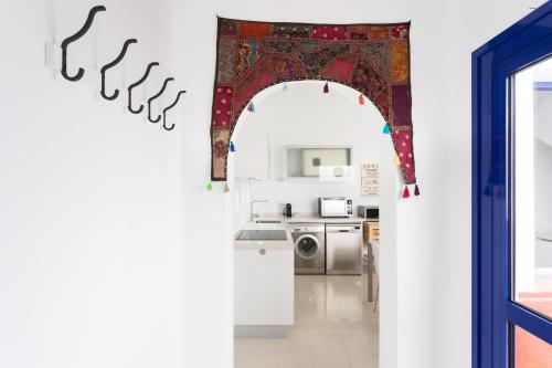 an archway leading into a kitchen with a washing machine at Casa Sirena in Santa Cruz de Tenerife