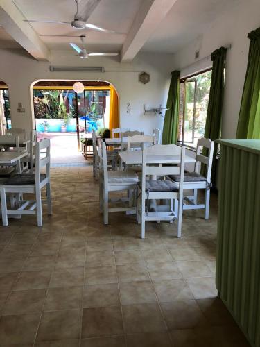 a dining room with white tables and chairs at Seaside Lodge B&B in Ballito