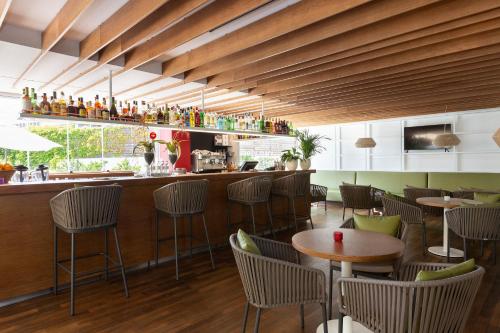 a restaurant with tables and chairs and a bar at Aimia Hotel in Port de Soller