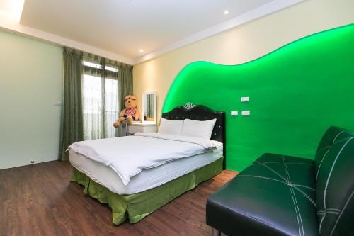 a green bedroom with a bed and a green headboard at Amir B&B train station & elevator with parking lot in Hualien City