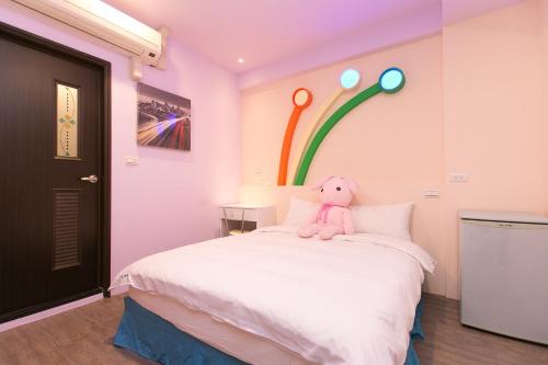 a teddy bear sitting on a bed in a room at Amir B&B train station & elevator with parking lot in Hualien City