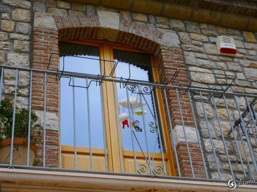 a window on a brick building with a iron fence at Masseria Fontana dei Fieri in Pietrelcina