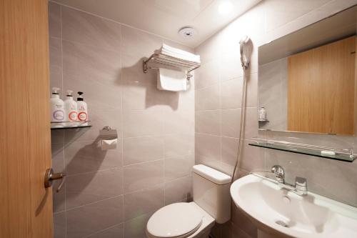 a bathroom with a toilet and a sink at MAMA Guesthouse Haeundae in Busan