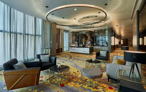 a hotel lobby with couches and tables and a chandelier at Pullman Kuala Lumpur City Centre Hotel & Residences in Kuala Lumpur