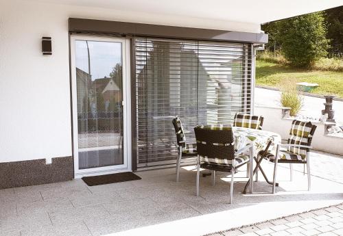 a patio with a table and chairs next to a sliding glass door at Ferienwohnung Angelina in Markdorf