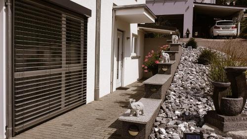 a cat sitting on a bench outside of a house at Ferienwohnung Angelina in Markdorf