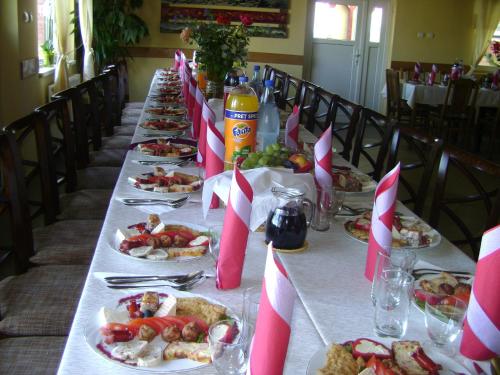 a long table with plates of food on it at Pensiunea Popasul Iancului in Mărişel