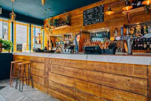 un bar en un restaurante con una pared de madera en The Mitre Hotel, en Mánchester