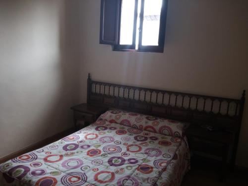 1 dormitorio con cama con almohada y ventana en Hostal Galicia, en Ribadeo