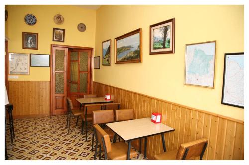 a dining room with two tables and chairs and a wall at Hostal Galicia in Ribadeo