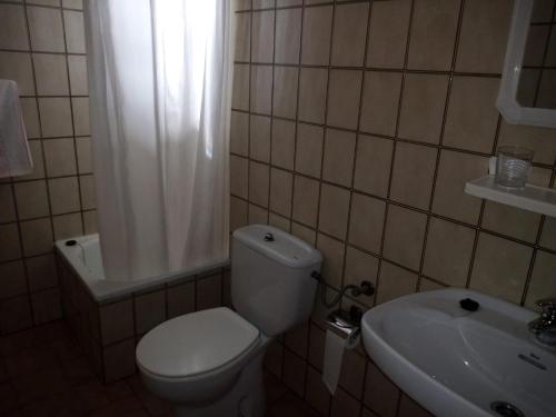 uma casa de banho com um WC branco e um lavatório. em Hostal Galicia em Ribadeo