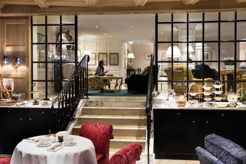 a restaurant with tables and chairs and a staircase at Relais Christine in Paris