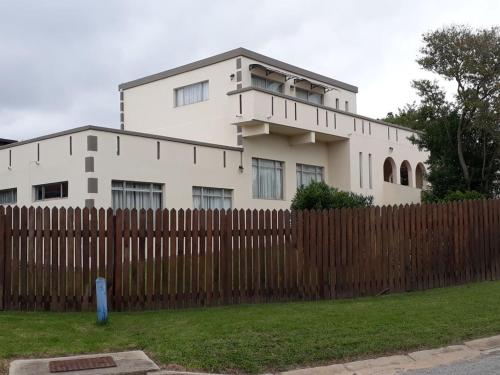 una casa blanca detrás de una valla de madera en Kasteel b&b, en Plettenberg Bay