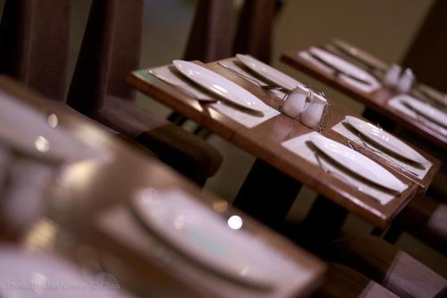 a row of wooden tables with knives and forks at Griffin Hotel and Suites in Cebu City