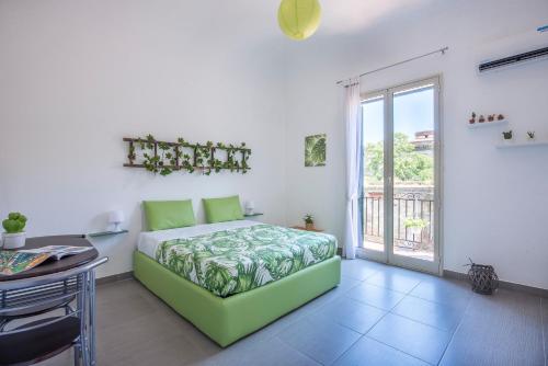 una camera con letto verde e balcone di De Valois Apartment a Palermo