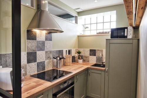 - une cuisine avec des comptoirs en bois et un réfrigérateur dans l'établissement Le Petit Porte Guillaume, à Chartres