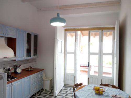 a kitchen with a table and a door to a patio at Marzamemi, campagna mare in Marzamemi