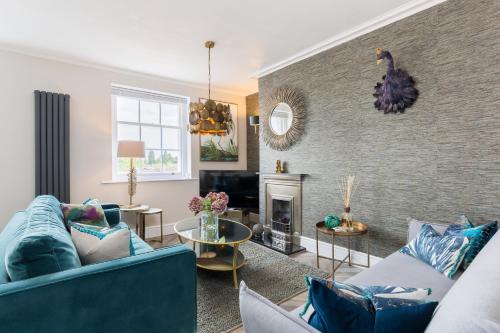 a living room with blue couches and a fireplace at L-Spa Boutique Apartments in Leamington Spa
