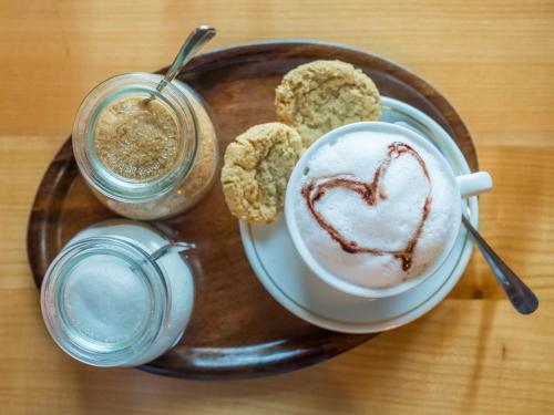 a plate with a cup of coffee and two drinks at Stöltings Landhaus in Wiehl
