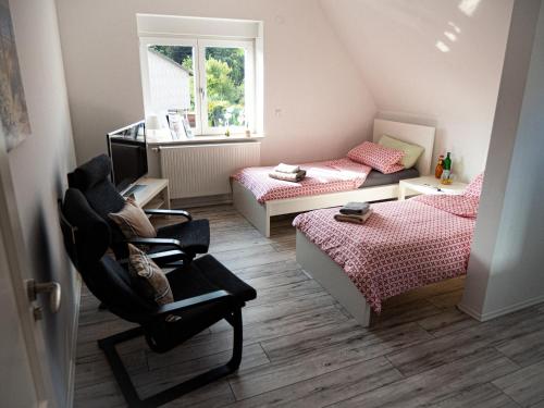 a small bedroom with two beds and a chair at Damm Apartments in Hannover