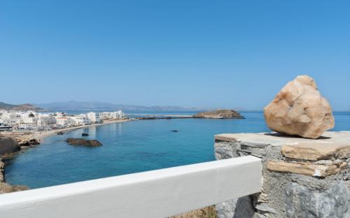 a rock sitting on a ledge overlooking the ocean at Iliada Suites in Naxos Chora