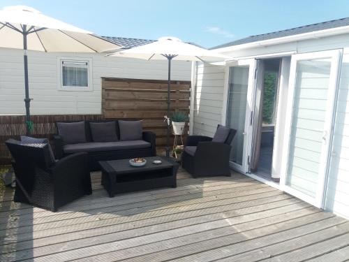 a patio with a couch and chairs and an umbrella at Vakantie Chalet Makkum in Makkum